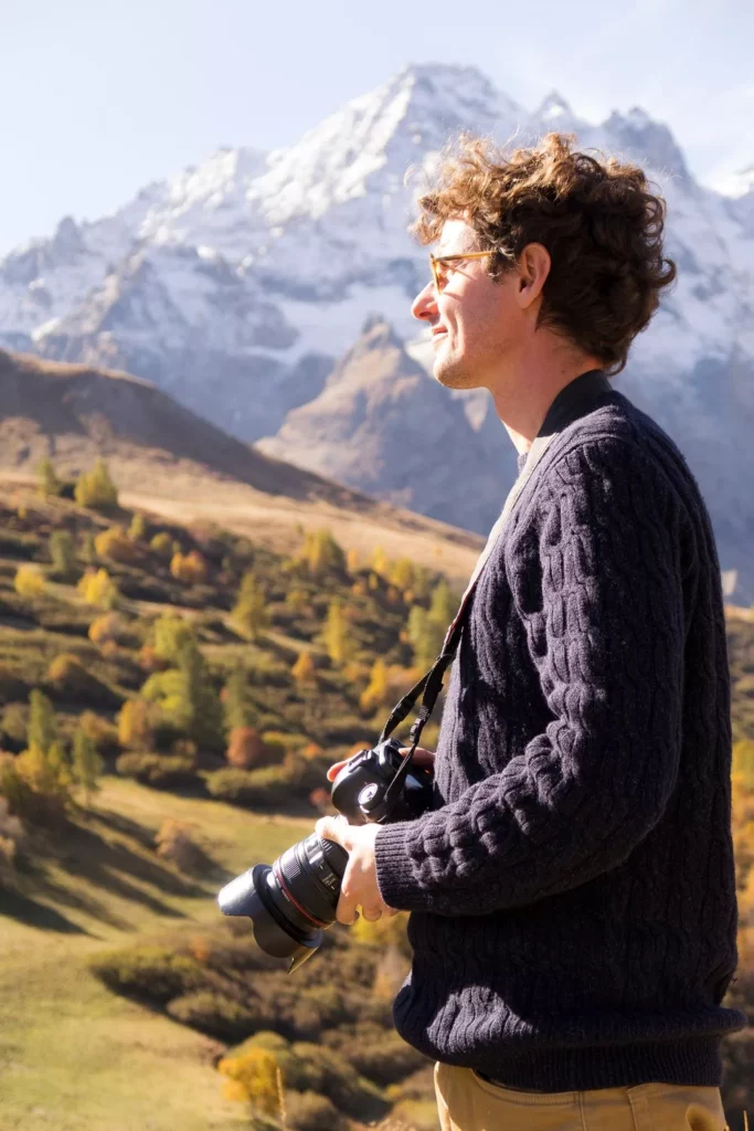 Nicolas Hodée, appareil à la main, en montagne